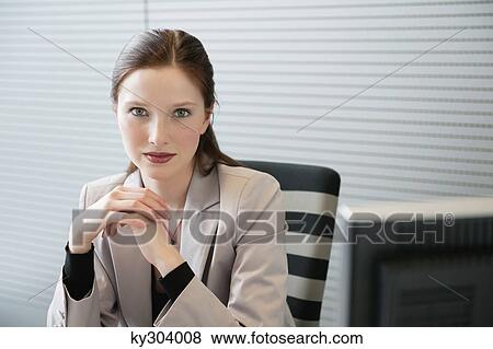 Businesswoman sitting in an office View Large Photo Image Stock Photo - Businesswoman sitting in an office. Fotosearch