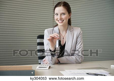 Female financial advisor holding a car key in an office View Large Photo Image Stock Image - Female financial advisor holding a car key in an office. Fotosearch