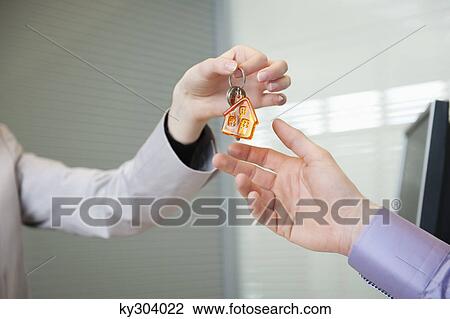 Female real estate agent giving house keys to a man View Large Photo Image Stock Image - Female real estate agent giving house keys to a man. Fotosearch