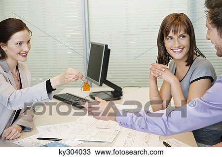 Female real estate agent giving house keys to a couple View Large Photo Image Stock Image - Female real estate agent giving house keys to a couple. Fotosearch