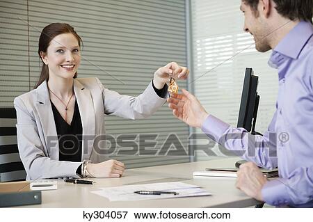 Female real estate agent giving house keys to a man View Large Photo Image Stock Photo - Female real estate agent giving house keys to a man. Fotosearch