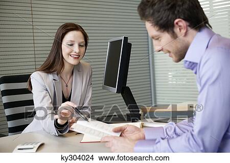 Female real estate agent showing a brochure to a man View Large Photo Image Picture - Female real estate agent showing a brochure to a man. Fotosearch