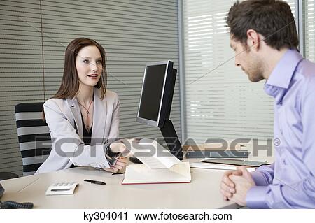 Female real estate agent showing a brochure to a man View Large Photo Image Stock Image - Female real estate agent showing a brochure to a man. Fotosearch
