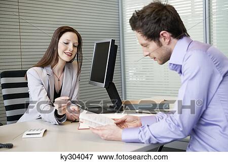 Female real estate agent showing a brochure to a man View Large Photo Image Stock Photo - Female real estate agent showing a brochure to a man. Fotosearch