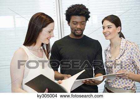 Business executives discussing documents in an office View Large Photo Image Picture - Business executives discussing documents in an office. Fotosearch