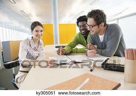 Business executives discussing documents in an office View Large Photo Image Stock Image - Business executives discussing documents in an office. Fotosearch