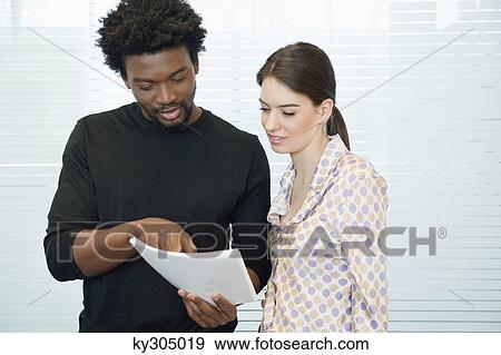 Business executives discussing documents in an office View Large Photo Image Stock Photo - Business executives discussing documents in an office. Fotosearch