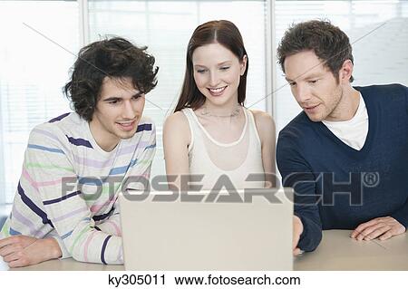 Business executives using a laptop in an office View Large Photo Image Stock Image - Business executives using a laptop in an office. Fotosearch