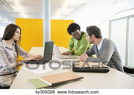 Business executives using laptops in an office View Large Photo Image Stock Photo - Business executives using laptops in an office. Fotosearch