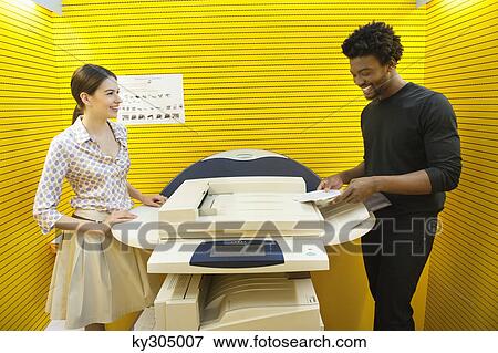Business executives using photocopy machine in an office View Large Photo Image Stock Photo - Business executives using photocopy machine in an office. Fotosearch