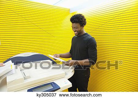 Businessman using a photocopy machine in an office View Large Photo Image Stock Photo - Businessman using a photocopy machine in an office. Fotosearch