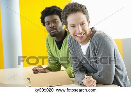 Businessmen smiling in an office View Large Photo Image Stock Image - Businessmen smiling in an office. Fotosearch