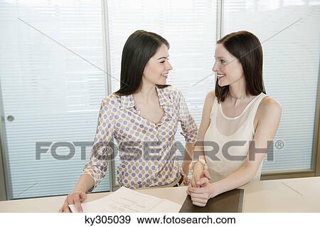 Stock Photo - Businesswomen smiling in an office. Fotosearch