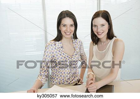 Businesswomen smiling in an office View Large Photo Image Stock Photo - Businesswomen smiling in an office. Fotosearch