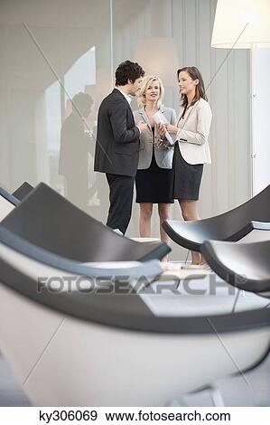 Stock Photo - Business executives discussing in an office. Fotosearch