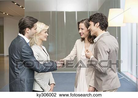 Stock Image - Business executives shaking hands. Fotosearch