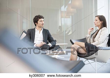 Business executives sitting on chairs in a waiting room View Large Photo Image Stock Photo - Business executives sitting on chairs in a waiting room. Fotosearch