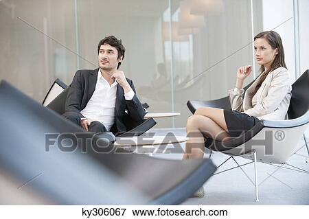 Business executives sitting on chairs in a waiting room View Large Photo Image Stock Photo - Business executives sitting on chairs in a waiting room. Fotosearch