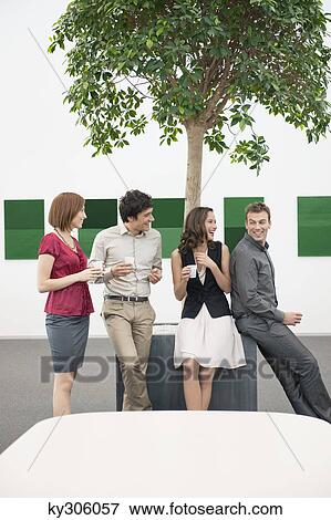 Stock Photo - Business executives talking to each other in a conference room during a coffee break. Fotosearch