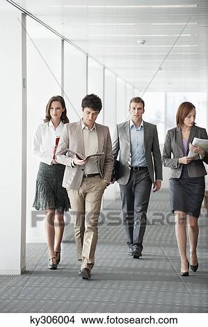 Business executives walking in the corridor of an office View Large Photo Image Picture - Business executives walking in the corridor of an office. Fotosearch