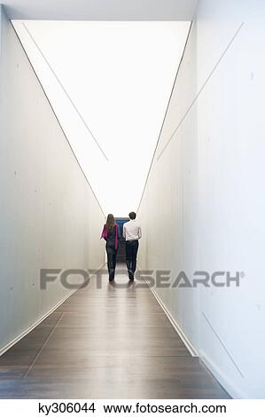 Picture - Business executives walking in the corridor of an office. Fotosearch