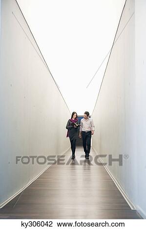 Business executives walking in the corridor of an office View Large Photo Image Stock Image - Business executives walking in the corridor of an office. Fotosearch