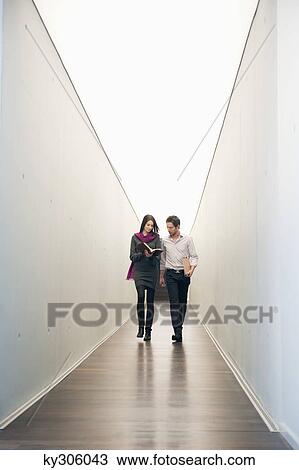 Business executives walking in the corridor of an office View Large Photo Image Stock Image - Business executives walking in the corridor of an office. Fotosearch