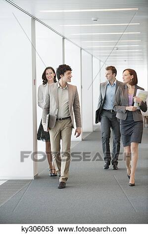 Business executives walking in the corridor of an office View Large Photo Image Stock Image - Business executives walking in the corridor of an office. Fotosearch