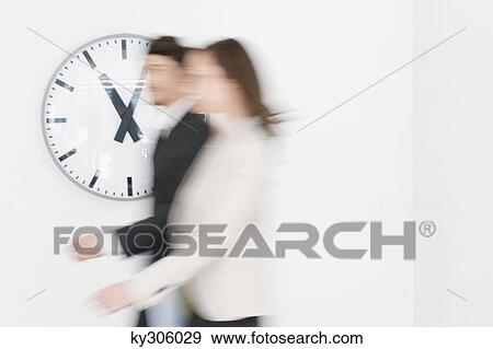 Business executives walking together in front of a wall clock View Large Photo Image Stock Photo - Business executives walking together in front of a wall clock. Fotosearch