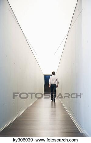 Stock Photo - Businessman walking in the corridor of an office. Fotosearch
