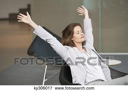 Businesswoman stretching in an office looking tired View Large Photo Image Stock Photo - Businesswoman stretching in an office looking tired. Fotosearch