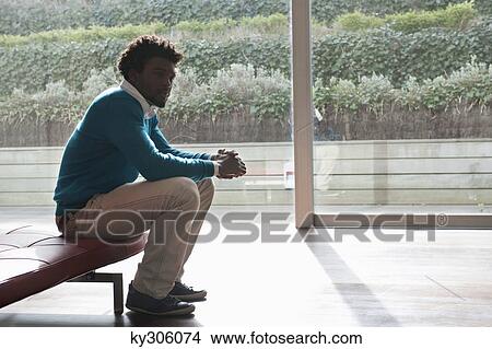 Man sitting on a couch and thinking View Large Photo Image Picture - Man sitting on a couch and thinking. Fotosearch