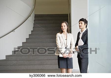 Two business executives standing in an office View Large Photo Image Stock Photograph - Two business executives standing in an office. Fotosearch