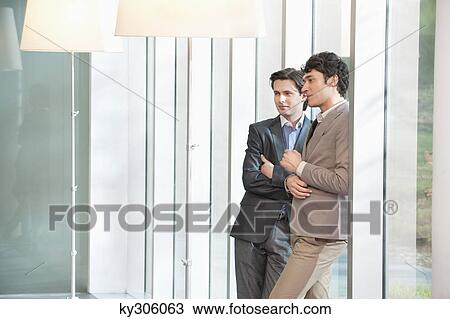 Two businessmen standing together View Large Photo Image Stock Image - Two businessmen standing together. Fotosearch