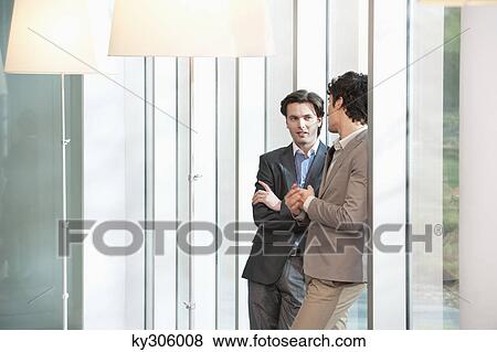 Two businessmen standing together View Large Photo Image Stock Photo - Two businessmen standing together. Fotosearch