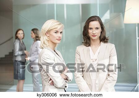 Two businesswomen standing together View Large Photo Image Stock Photograph - Two businesswomen standing together. Fotosearch