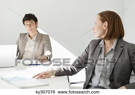Stock Photograph - Business executives discussing in a conference room. Fotosearch
