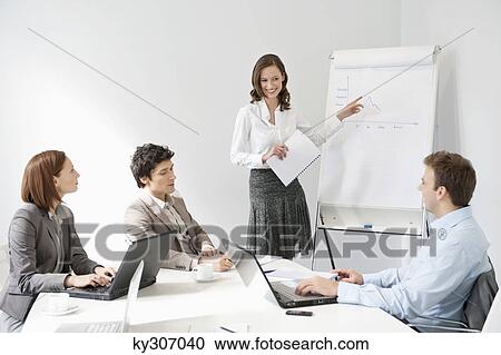Stock Image - Businesswoman giving presentation in a meeting. Fotosearch
