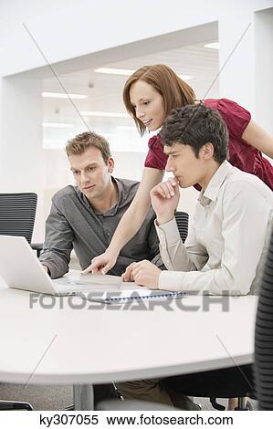 Businesswoman with two businessmen working in an office View Large Photo Image Stock Photography - Businesswoman with two businessmen working in an office. Fotosearch