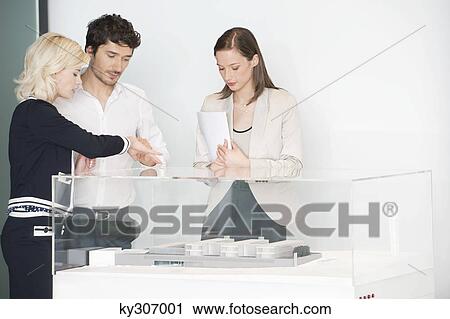 Man with two women looking at an architectural model View Large Photo Image Stock Image - Man with two women looking at an architectural model. Fotosearch