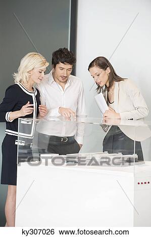 Man with two women looking at an architectural model View Large Photo Image Stock Photograph - Man with two women looking at an architectural model. Fotosearch