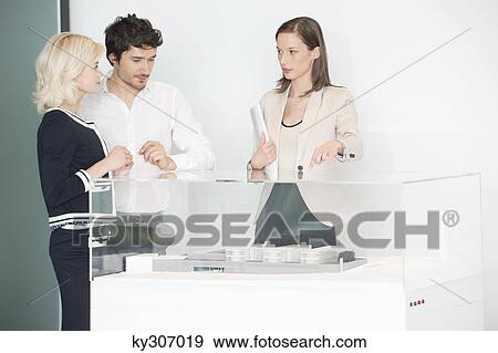 Man with two women near an architectural model View Large Photo Image Stock Photo - Man with two women near an architectural model. Fotosearch