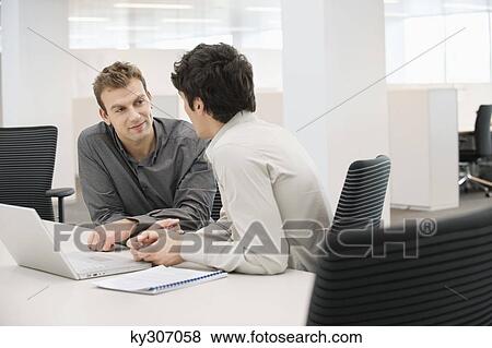 Stock Photo - Two businessmen discussing each other in an office. Fotosearch