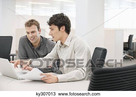 Two businessmen working in an office View Large Photo Image Stock Image - Two businessmen working in an office. Fotosearch