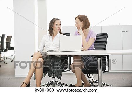 Two businesswomen working in an office View Large Photo Image Stock Image - Two businesswomen working in an office. Fotosearch