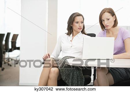 Two businesswomen working in an office View Large Photo Image Stock Image - Two businesswomen working in an office. Fotosearch
