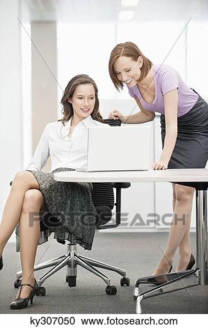 Two businesswomen working in an office View Large Photo Image Stock Image - Two businesswomen working in an office. Fotosearch