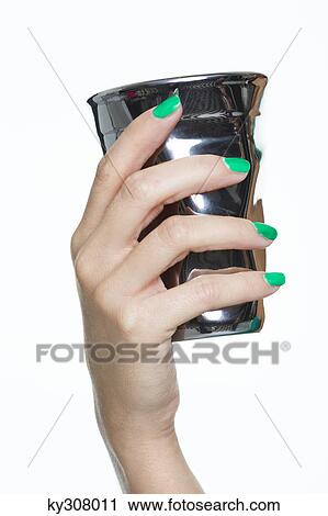 Stock Image - Close-up of woman's hand holding silver cup. Fotosearch