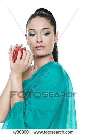 Stock Image - Young woman holding an apple. Fotosearch