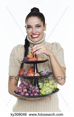 Young woman holding fruit dish View Large Photo Image Stock Photograph - Young woman holding fruit dish. Fotosearch